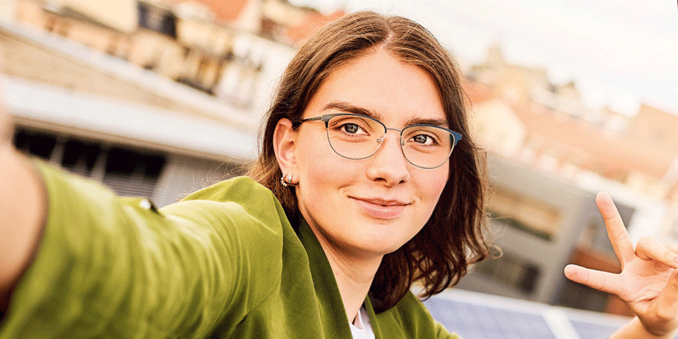 Eine Jugendliche sieht in die Kamera und freut sich.