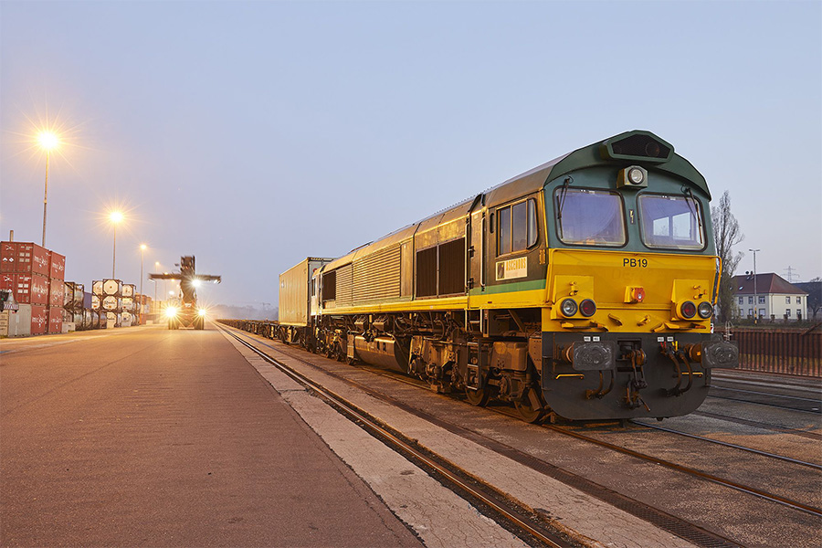 Reachstacker und Zug an der Hafenanlage.