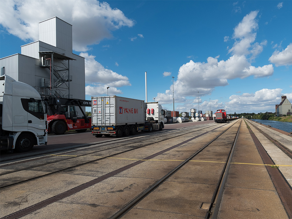 Hafenanlage mit gleisen und LKWS.