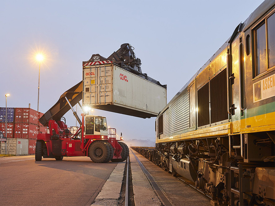 Bahn wird mit einem Container beladen.